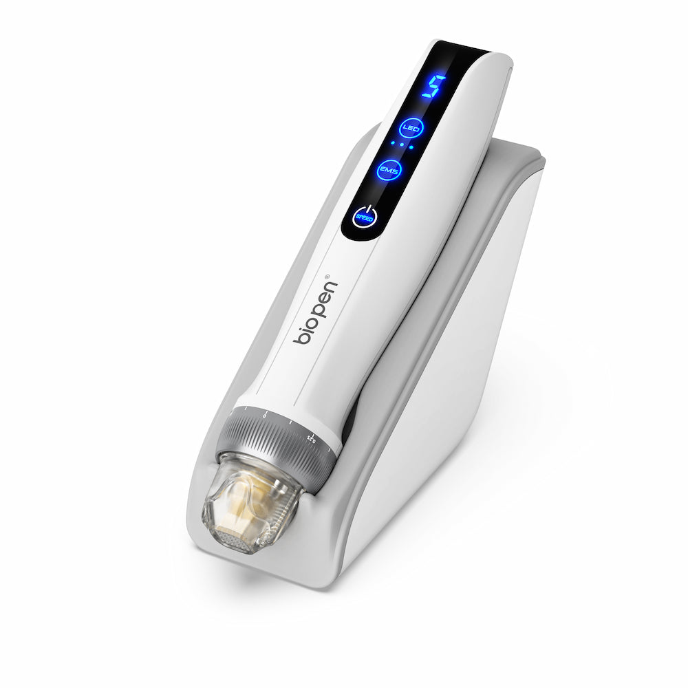 Caneta BioPen branca Q2 microneedling colocada em um suporte branco, com display digital de LED azul e módulo de agulha transparente.