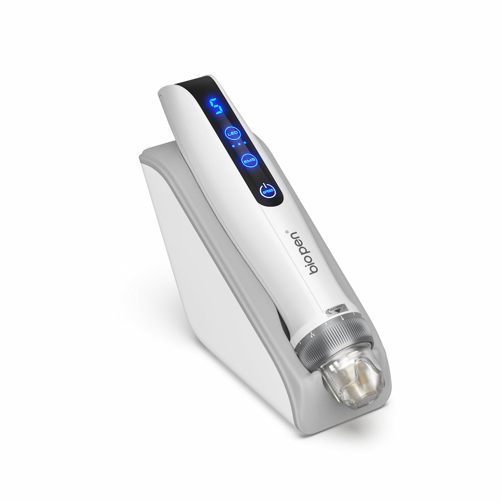 Caneta BioPen branca Q2 microneedling colocada em um suporte cinza, com display de LED azul e módulo de agulha transparente na frente.