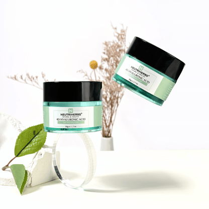 Imagem de lifestyle de Neutriherbs 4D Hyaluronic Acid Gel Moisturizer 50 g. Dois frascos do gel-creme hidratante são apresentados num ambiente claro e elegante, com detalhes naturais que transmitem uma rotina de cuidados de pele fresca e hidratação intensa.